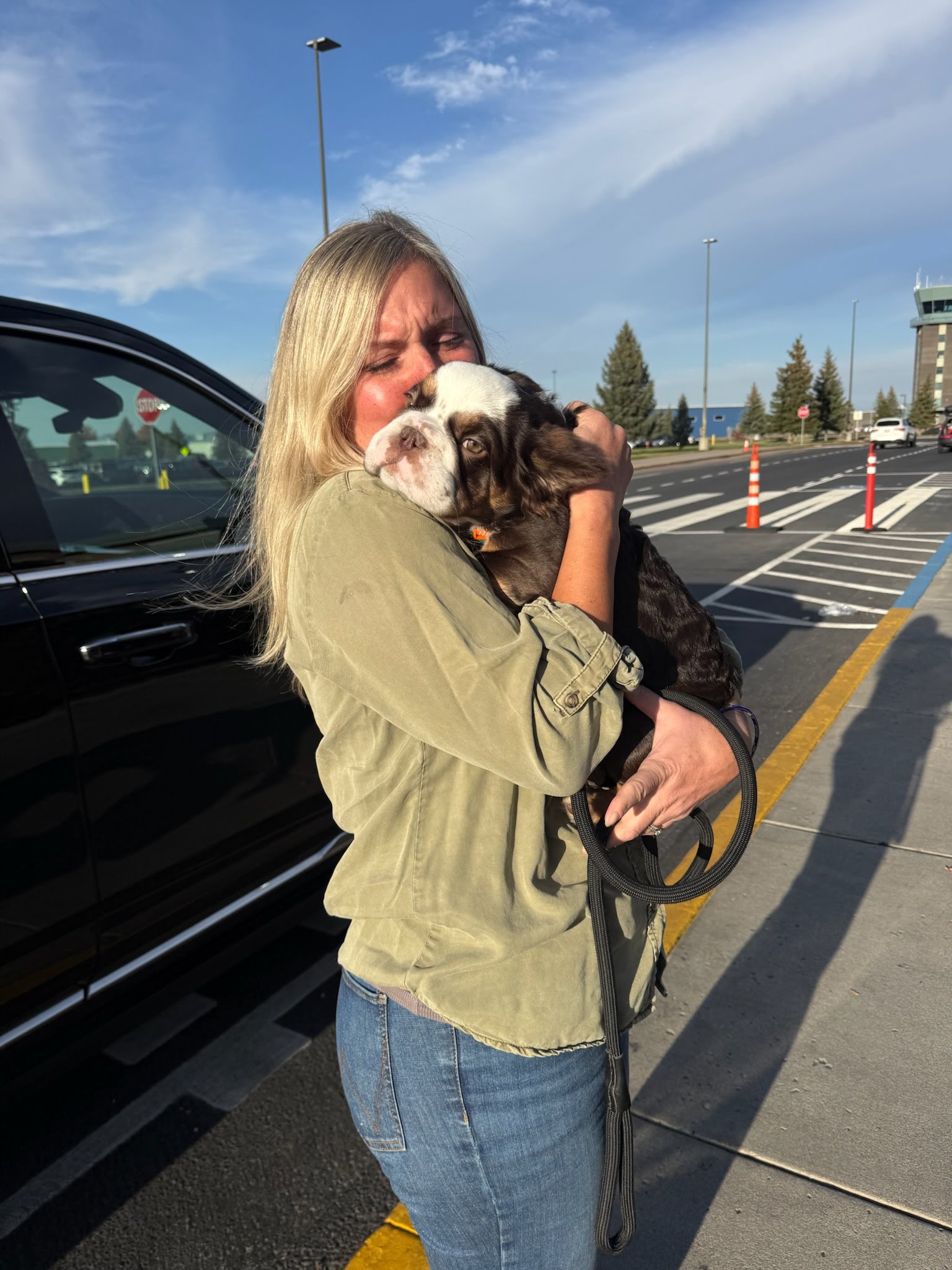 A woman welcoming her dog at an airport pickup